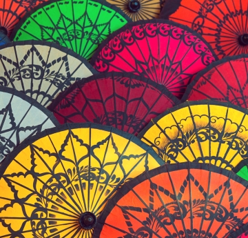 overhead image of tops of colorful Burmese umbrellas