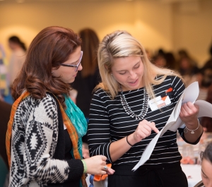 two women reading a conference program
